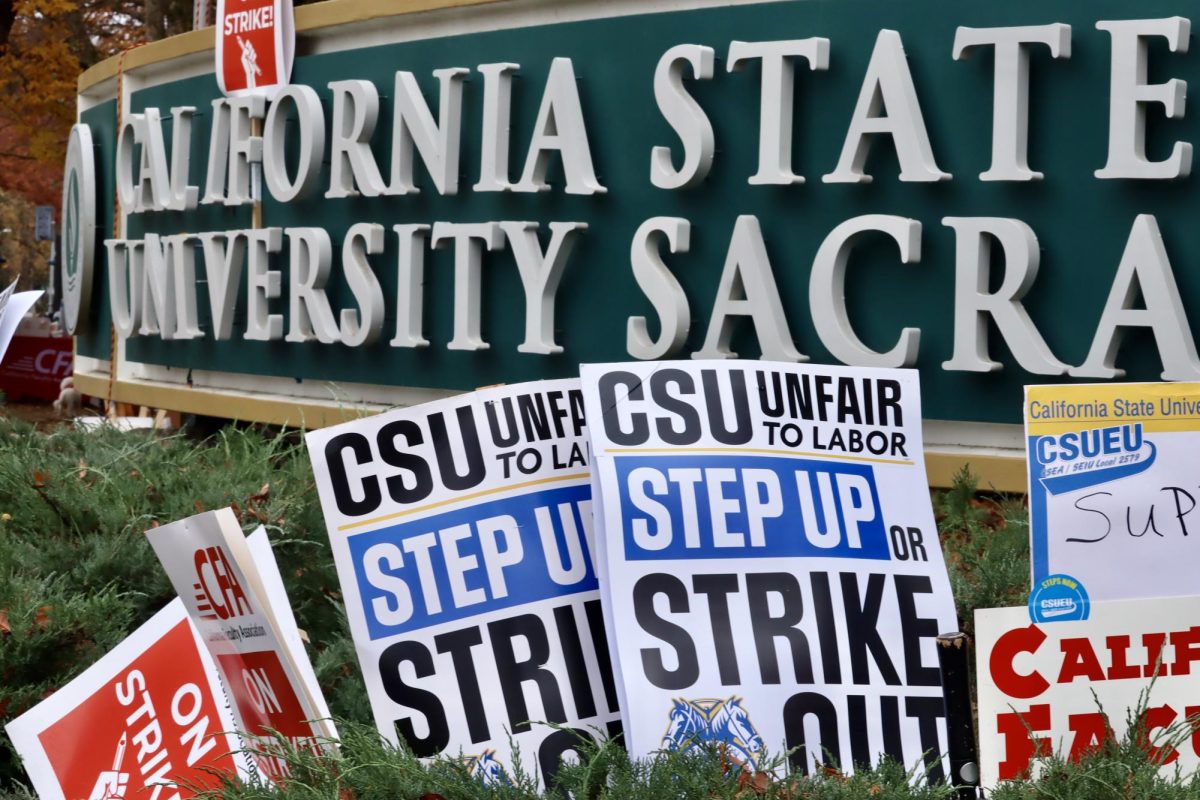 Signs in front of a California State University, Sacramento sign on Dec. 7, 2023. (Adriana Hernandez/Golden Gate Xpress)