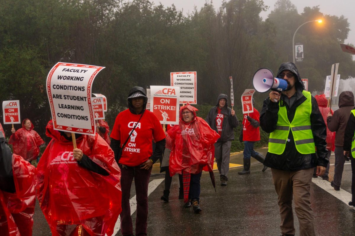 David Steel (right), a CFA field representative chants through a mega horn on the picket line on the CSU East Bay campus in Hayward, Calif. on Monday, Jan. 22, 2024. 