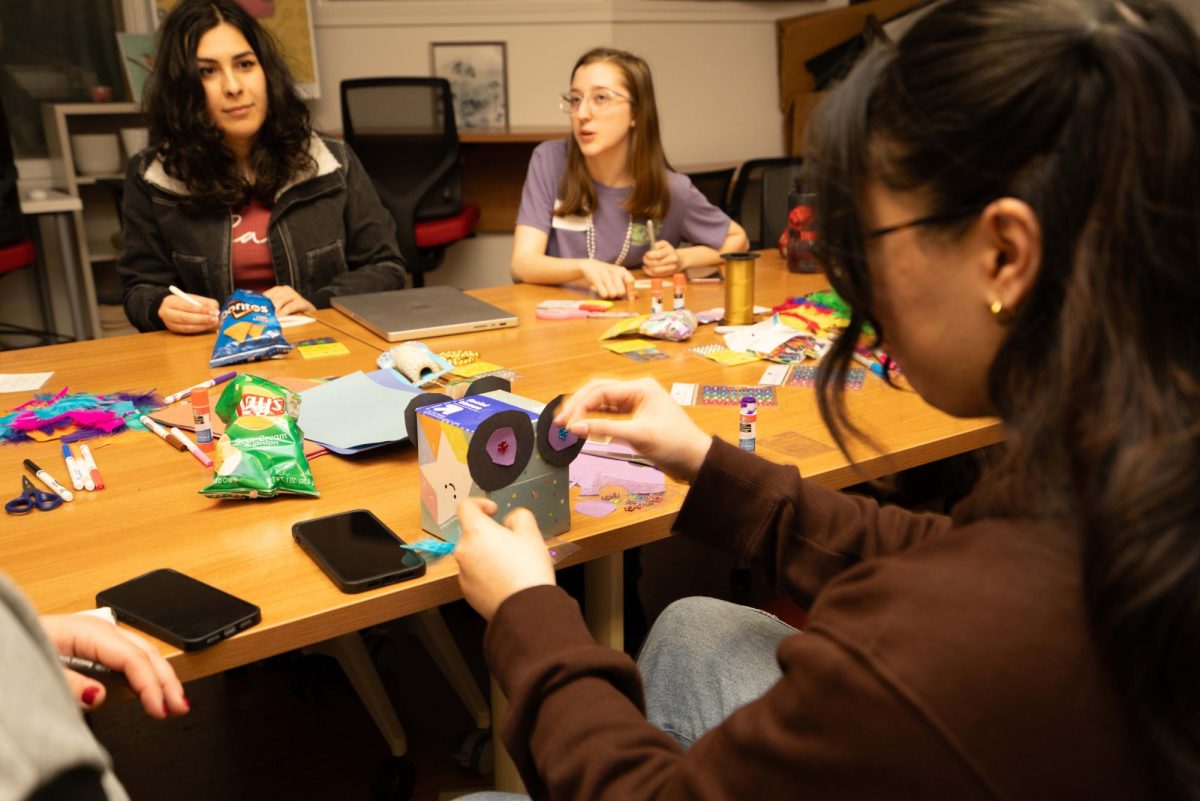 Tria Rosa Valbuena, treasurer and digital designer of Queer Alliance, (left) Lily Eiselt, Director (center) celebrate Mardi Gras this year by constructing mini parade floats and face masks on February 20, 2024 (Gustavo Hernandez / Golden Gate Xpress)