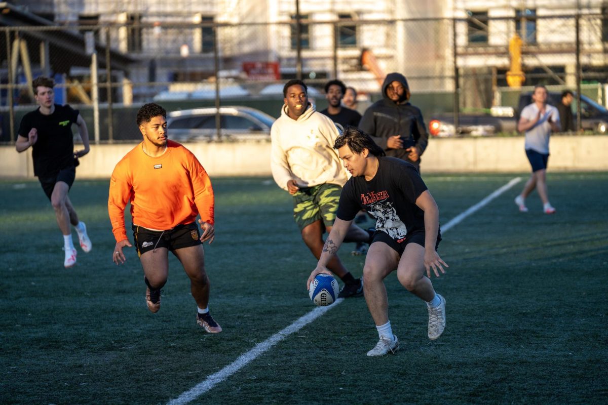 Several members of SFSU’s men’s rugby team attempt to tackle a teammate during practice on Tuesday at the field outside Mashouf Wellness Center. (Sean Young / Golden Gate Xpress)