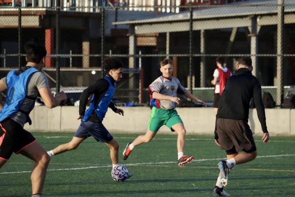 Uilliam Garduno, third-year student, runs with the ball across the field during a scrimmage between those trying out and those already on the team at SF State’s All Purpose Field on Feb. 19, 2024. (Adriana Hernandez / Golden Gate Xpress) 