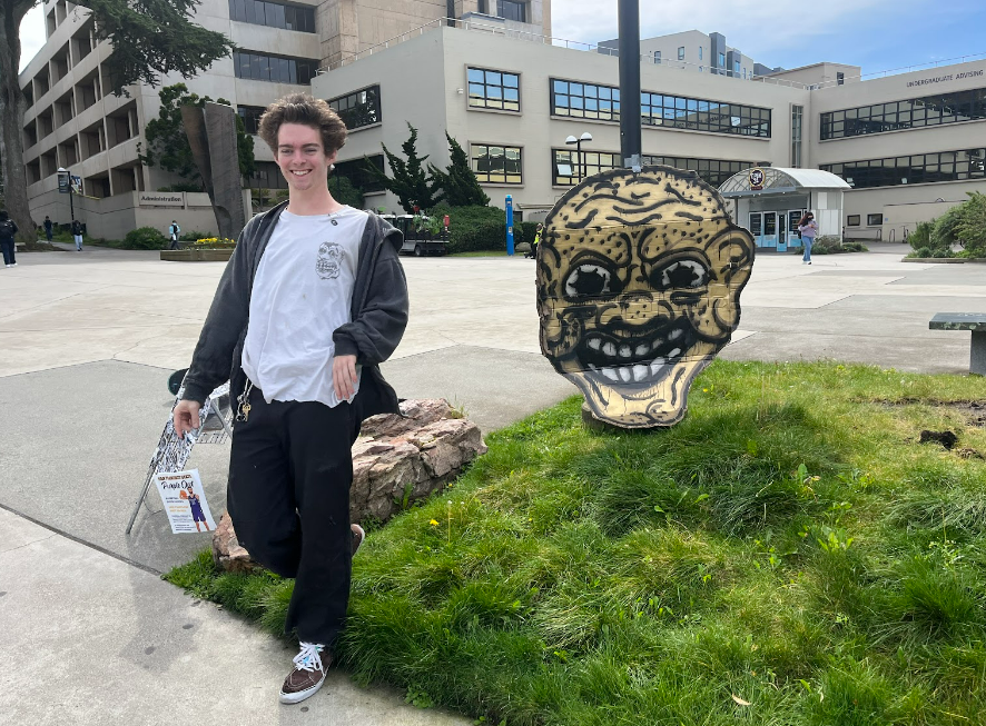 Ed poses with his art near the administration building at San Francisco State University on Tuesday, March 12, 2024. (Jonah Chambliss / Golden Gate Xpress)