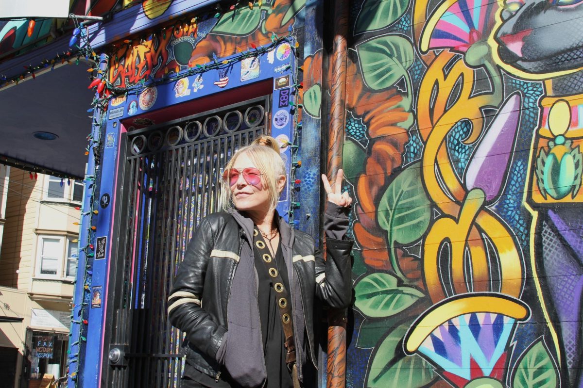 Linda Kelly throwing up a peace sign on Haight Street in San Francisco on March 13, 2024. (Paula Sibulo for Golden Gate Xpress)
