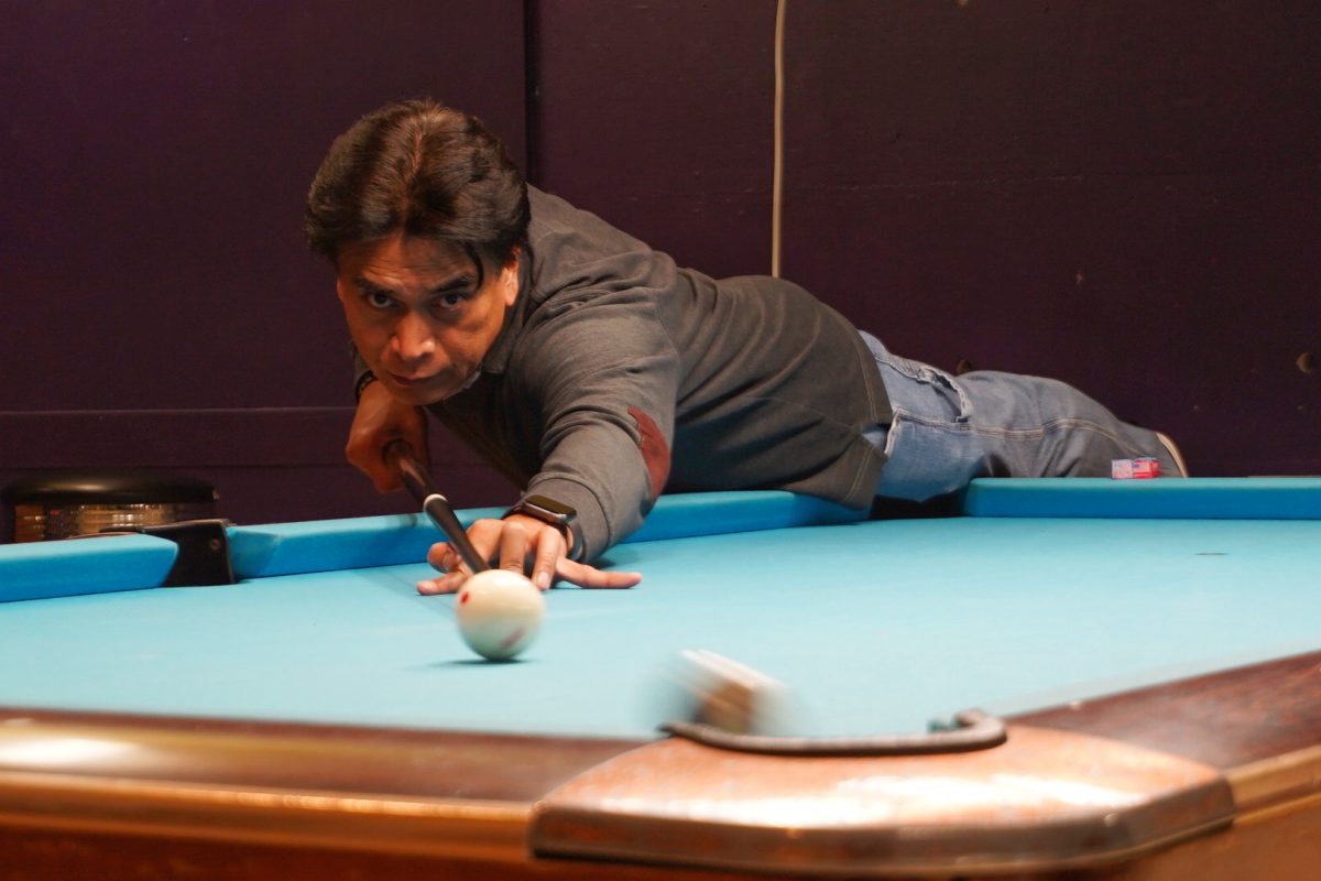 Primo Estillomo plays pool at Rack-N-Cue on March 21, 2024. (Neal Wong / Golden Gate Xpress)