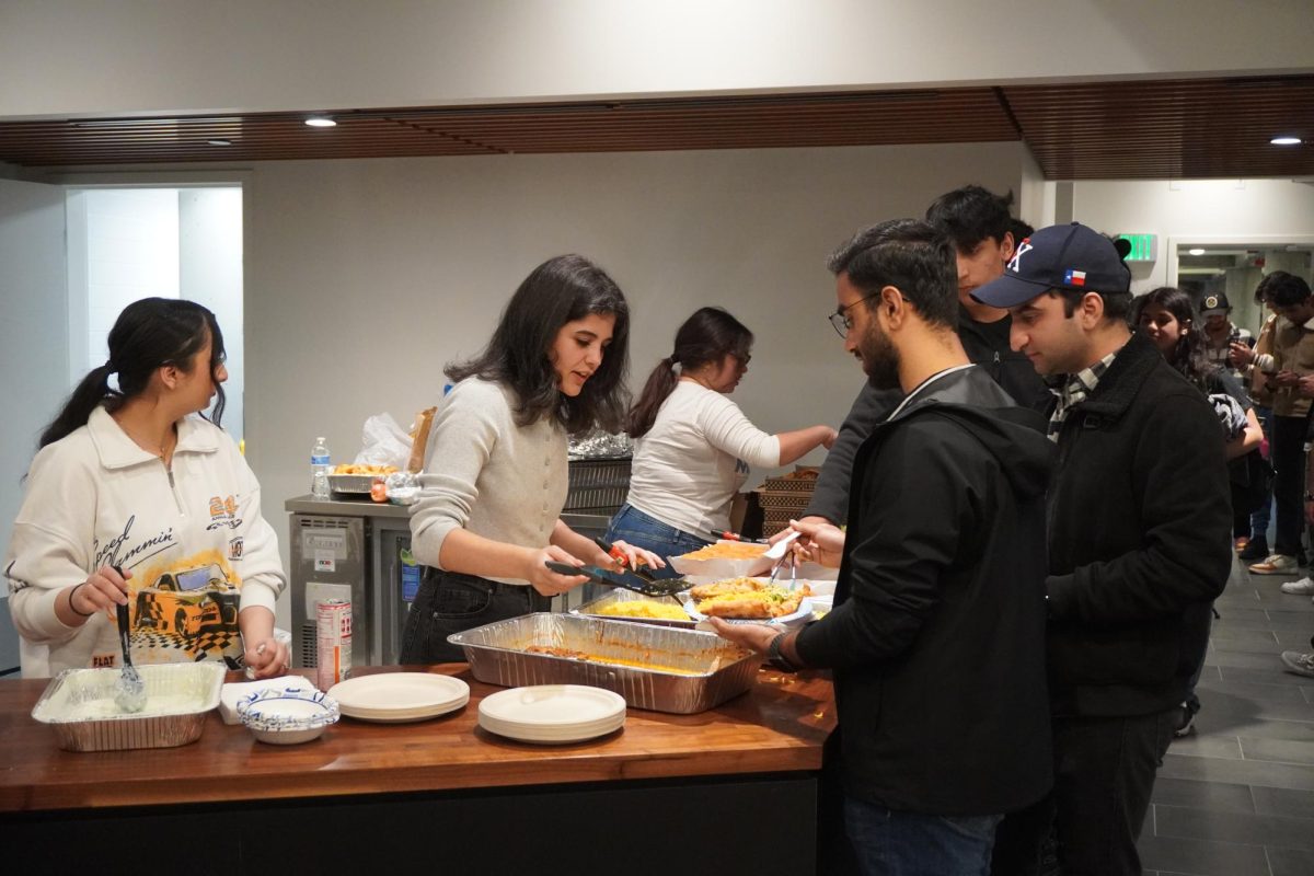 Muslim Student Life program coordinator Sara Alhanich serves food to an attendee in the university club on April 2, 2024. (Kiren Kaur / Golden Gate Xpress)