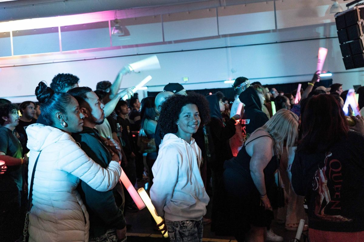 An attendee smiles in the crowd during the show at the 12th Annual Rhythms Music Festival in Annex I at SFSU on May 13, 2023. (David Jones / Golden Gate Xpress)
