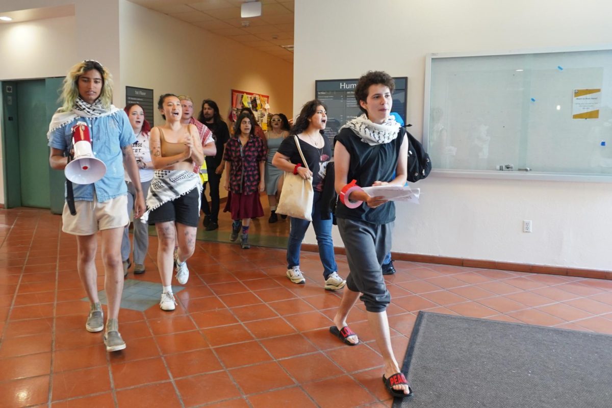 Pro-Palestinian protestors march, chant and place flyers in the Humanities Building on May 9, 2024. (Neal Wong / Golden Gate Xpress)