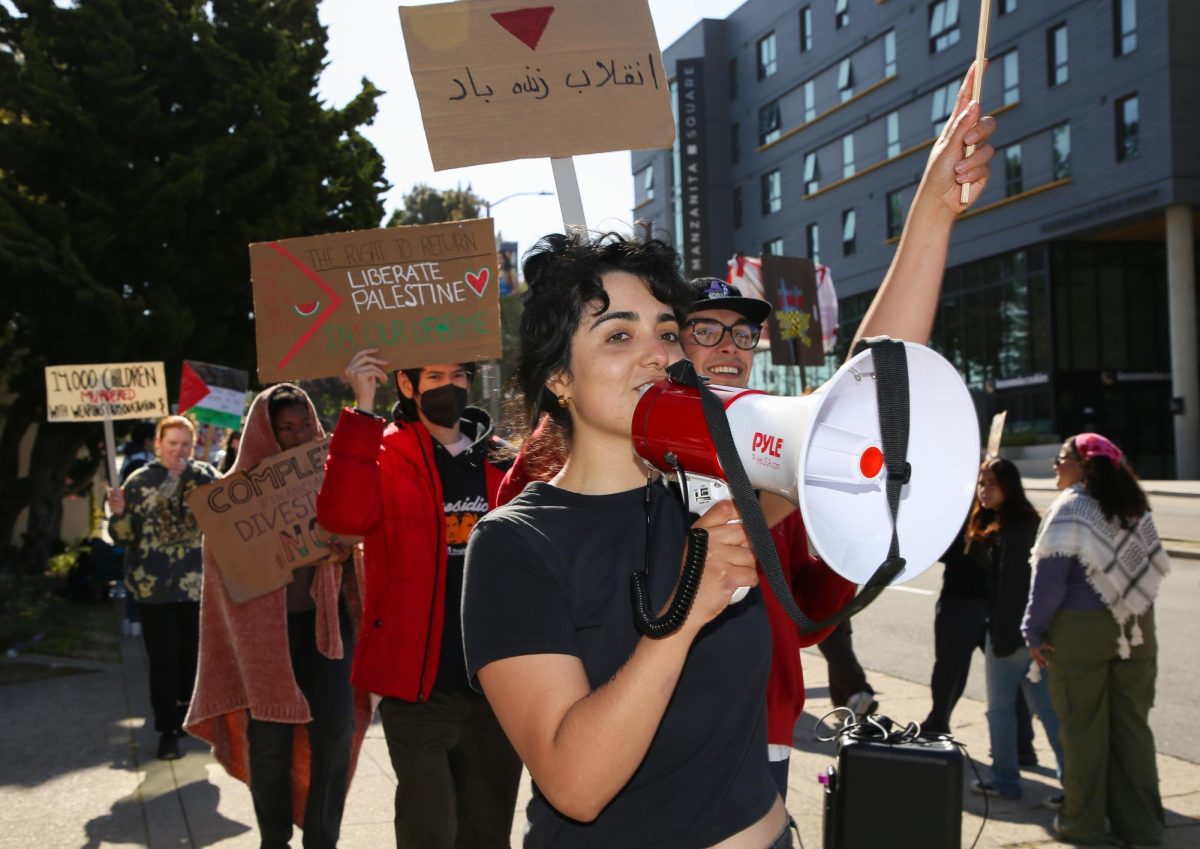 Rally participants lead chants, requesting that SFSU administration meet their demands, outside the Administration Building on May 7, 2024. (Tâm Vũ / Golden Gate Xpress)