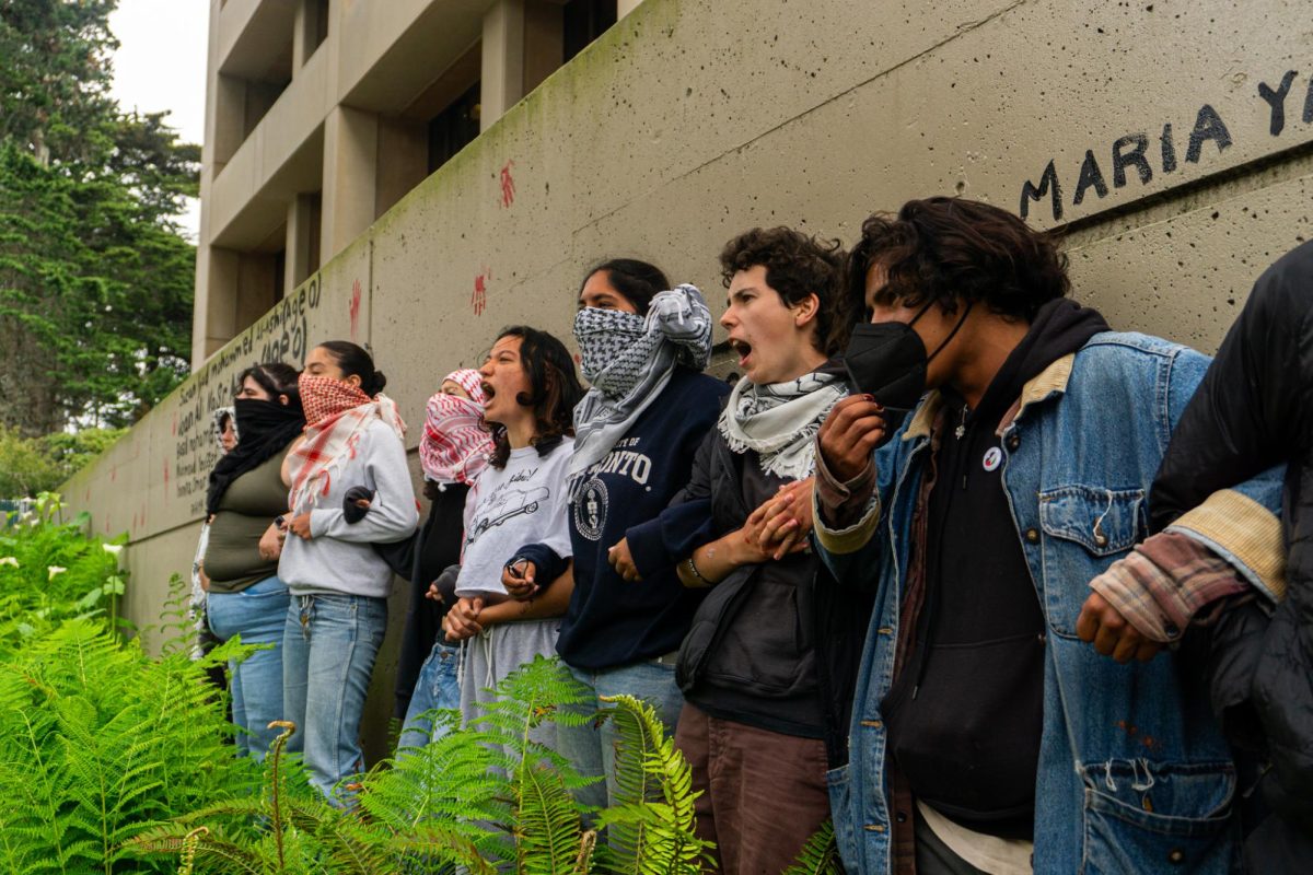 Protestors lock arms as they chant in front of the Administration Building at San Francisco State University on Monday, May 13, 2024. (Dan Hernandez / Golden Gate Xpress)