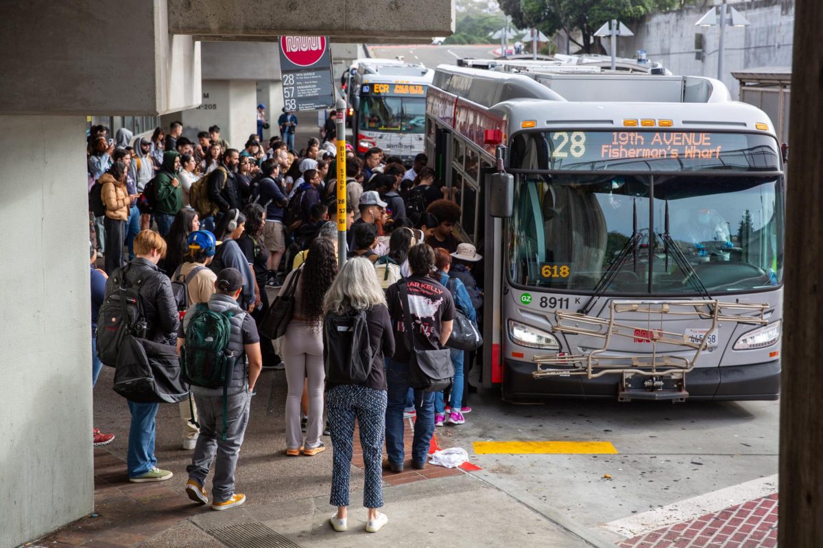 A crowd of commuters wait to board a Muni 28-19th Ave bus at the Daly City BART station on the morning of Wednesday, Aug. 28, 2024. A Muni 28 bus can reach up to 125% of the suggested 63 passenger capacity during peak commuting hours. (Dan Hernandez / Golden Gate Xpress)