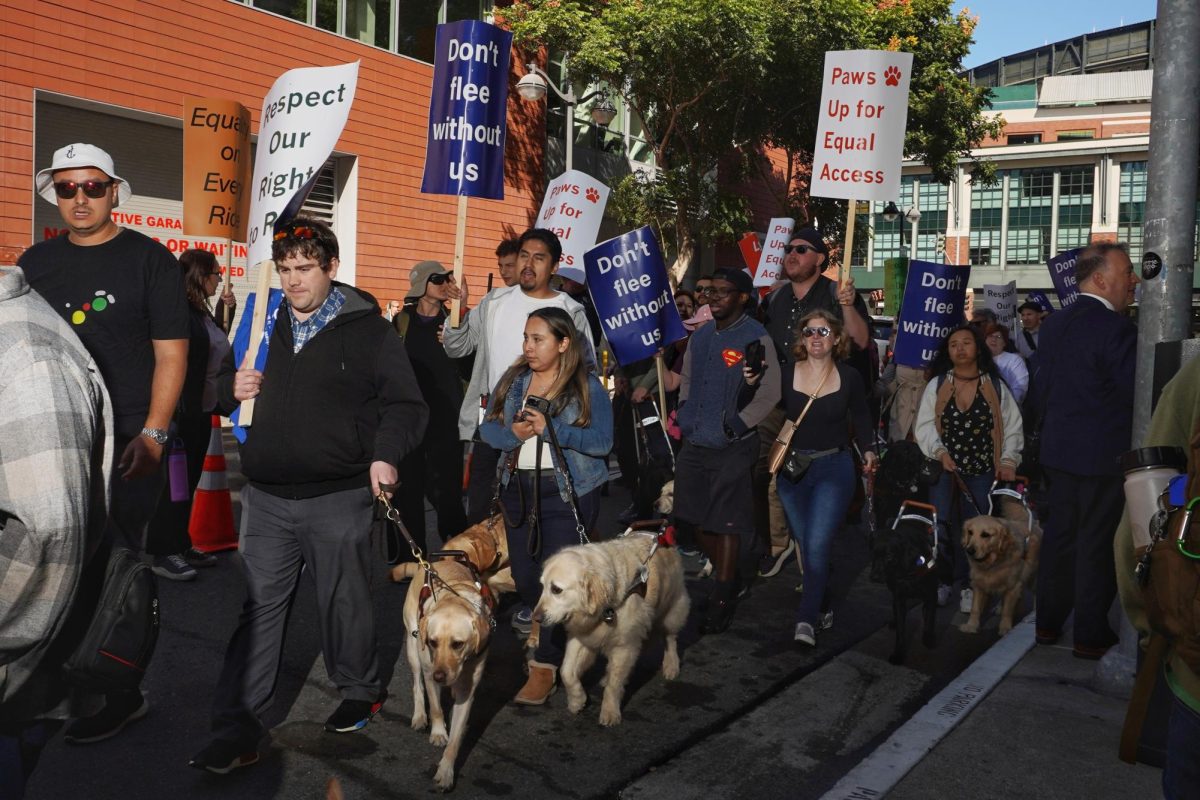 Protesters picket against rideshare denials to blind people with guide dogs, outside Lyft headquarters on Tuesday, Oct. 15, 2024. They protested outside Uber headquarters earlier. (Neal Wong / Golden Gate Xpress)