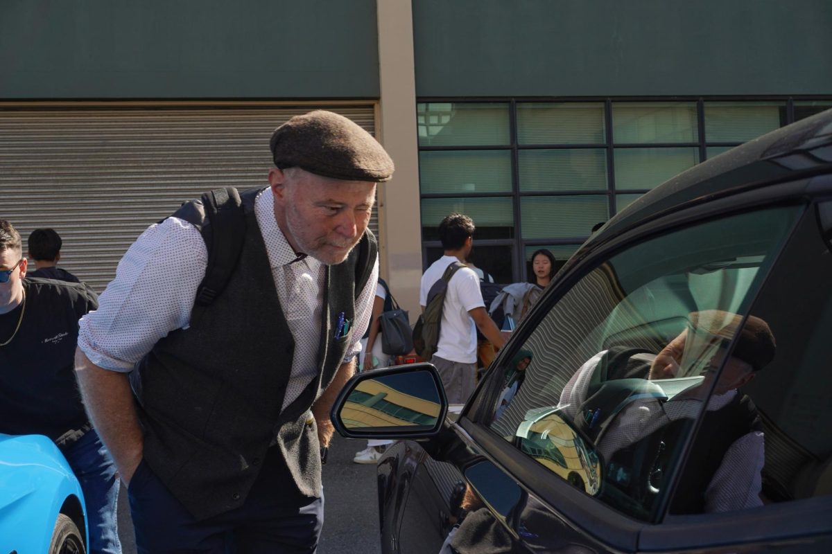 John Ryan looks inside a car during the Gator Greasers car show on Tuesday, Oct. 1, 2024. (Neal Wong / Golden Gate Xpress)