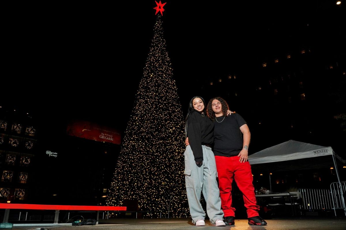 (L-R) Elana Carrier and Dominick Perez pose for a photo near Macy’s Great Tree in Union Square, San Francisco on Wednesday, Nov. 13, 2024. (Neal Wong / Golden Gate Xpress)