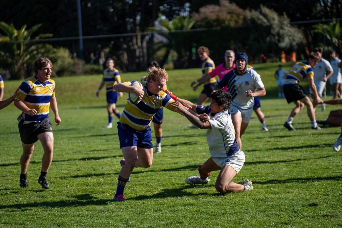 Nikolai Hungate, SFSU rugby club president, pushes away a defender from the University of Nevada, Reno at Matthew J. Boxer Stadium in San Francisco on Nov. 9, 2024. (Sean Young / Golden Gate Xpress)