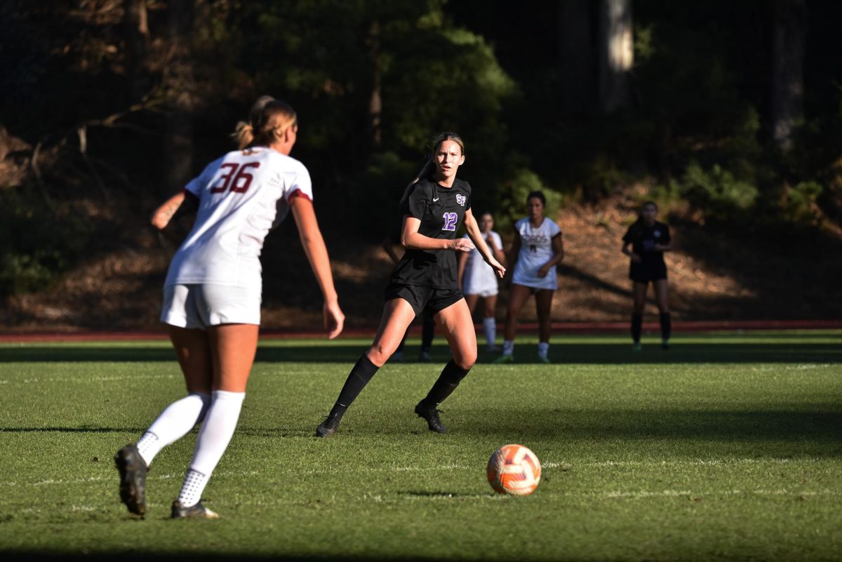 Kelsey Burrus (center), a junior defender for the SFSU women’s soccer team, watches Kaila Tone (left), a sophomore defender for Cal State Dominguez Hills, push the ball up the pitch at Cox Stadium on Sunday, Nov. 3, 2024. (Vanden Harris special to Golden Gate Xpress)