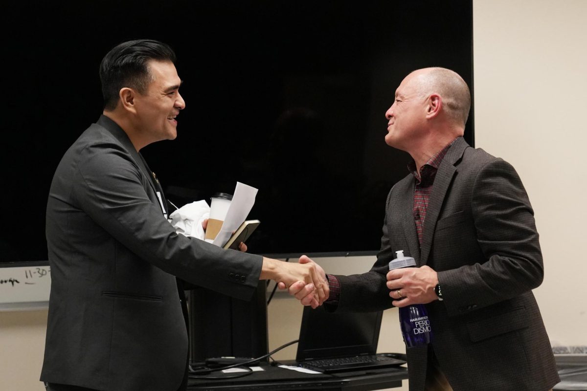 Jose Antonio Vargas (left) a journalist and CSU Trustee, shakes the hand of Jesse Garnier, the chair of the Journalism department, at an open forum event in Humanities Building Room 309 on Wednesday, Dec. 4, 2024.