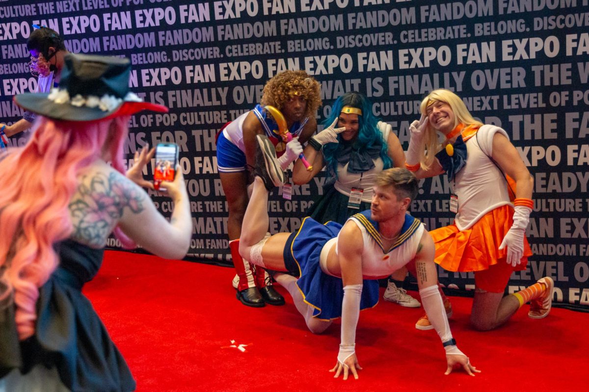 Convention attendees dressed in cosplay pose together for a photo on the red carpet at Fan Expo 2024 in the Moscone West Convention Center on Saturday, Nov. 30, 2024. (Dan Hernandez / Golden Gate Xpress)