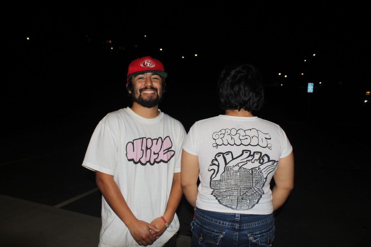 Julian y Sarahí Rodriguez con camisetas puestas de su negocio 4life fuera de su estudio en Hunters Point el día 25 de febrero de 2025. (Melissa Garcia / Golden Gate Xpress)