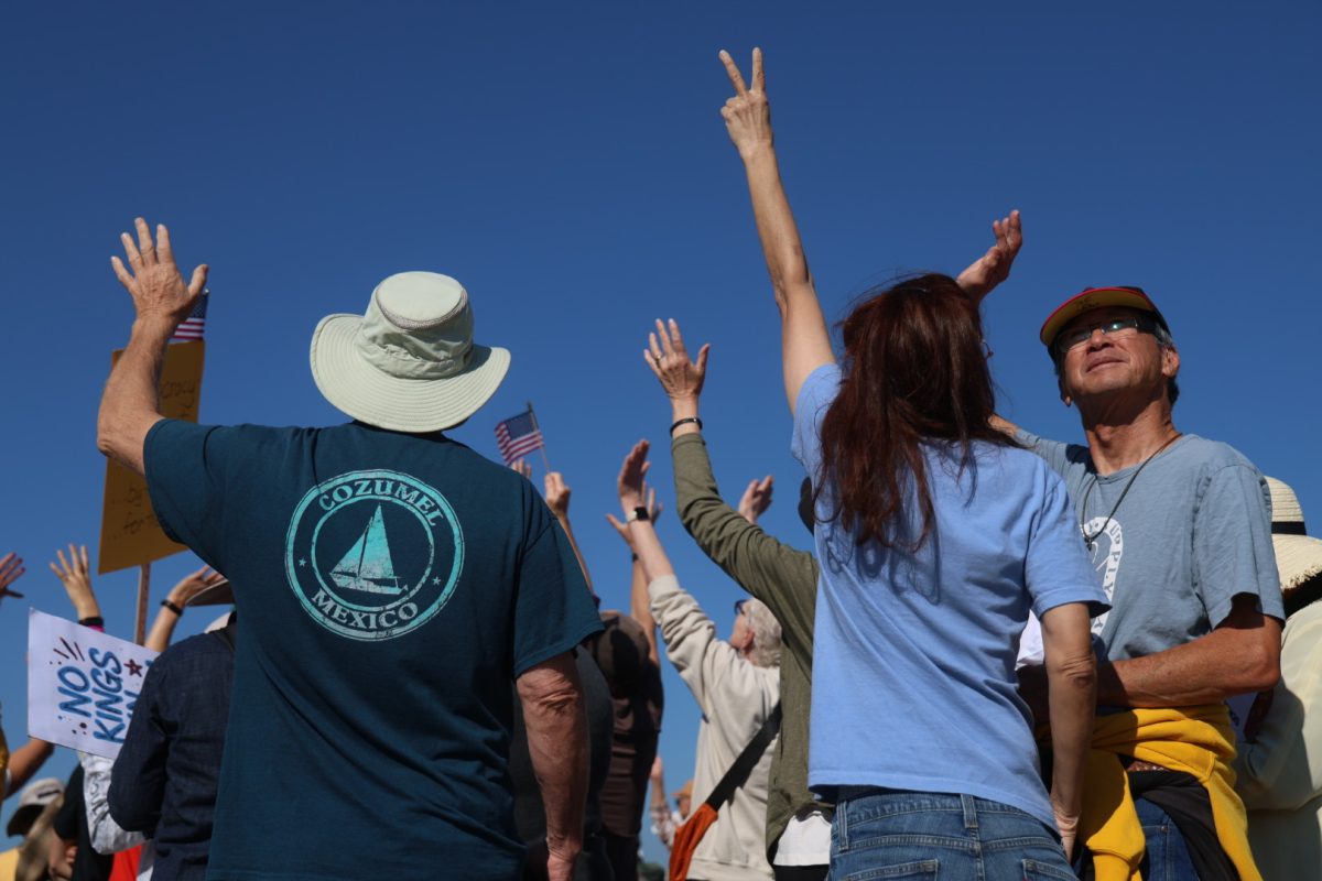 Protesters wave at a passing helicopter during the “No Kings” protest at Ocean Beach on Saturday, Oct. 18, 2025. (Braelyn Furse / Golden Gate Xpress)