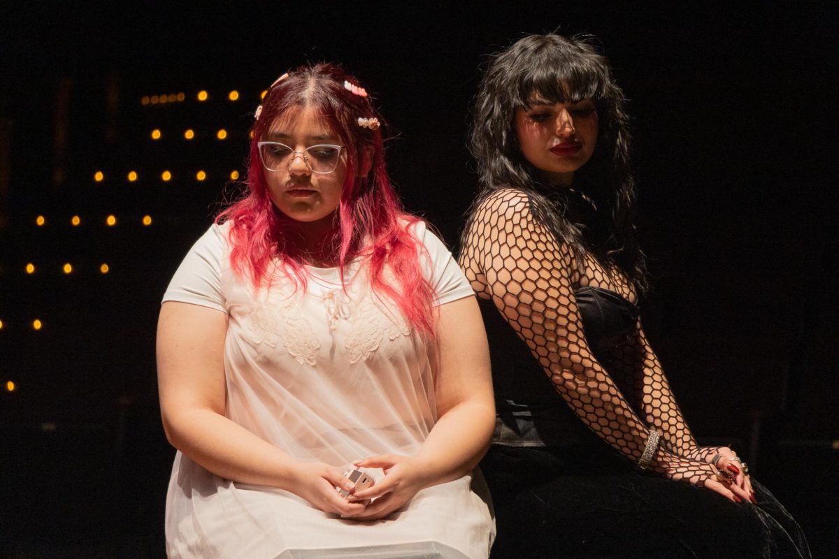 Actor Sophia Rodriguez (left) sits beside actor Danielle Citali Valdivieso (right) during a scene in the final dress rehearsal of “Camp S.L.A.Y.” in The Lab on Monday, Dec. 1, 2025. Rodriguez’s character, Maya, is coupled up with Valdivieso’s character, Indigo, during an emotional group exercise at camp, in order to get to know one another better. (Jolie Willson / Golden Gate Xpress)