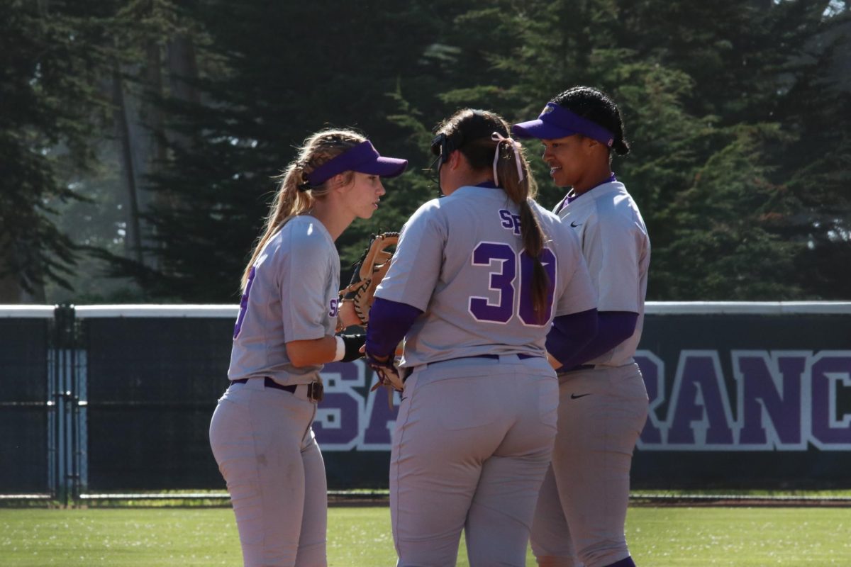 San Francisco State University softball infielders Lexi Holihan, Shaunessy Cardwell, and pitcher Mari Takeda Bajan huddle between hitters in their game against Sonoma State University on March 7, 2025. (Gwen Murray / Golden Gate Xpress)